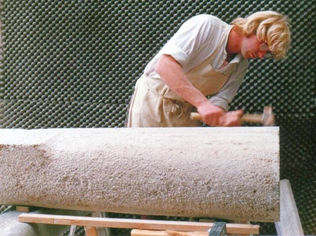 The sculptor Wolfgang Sandt working on a grave sculpture in form of ammonite